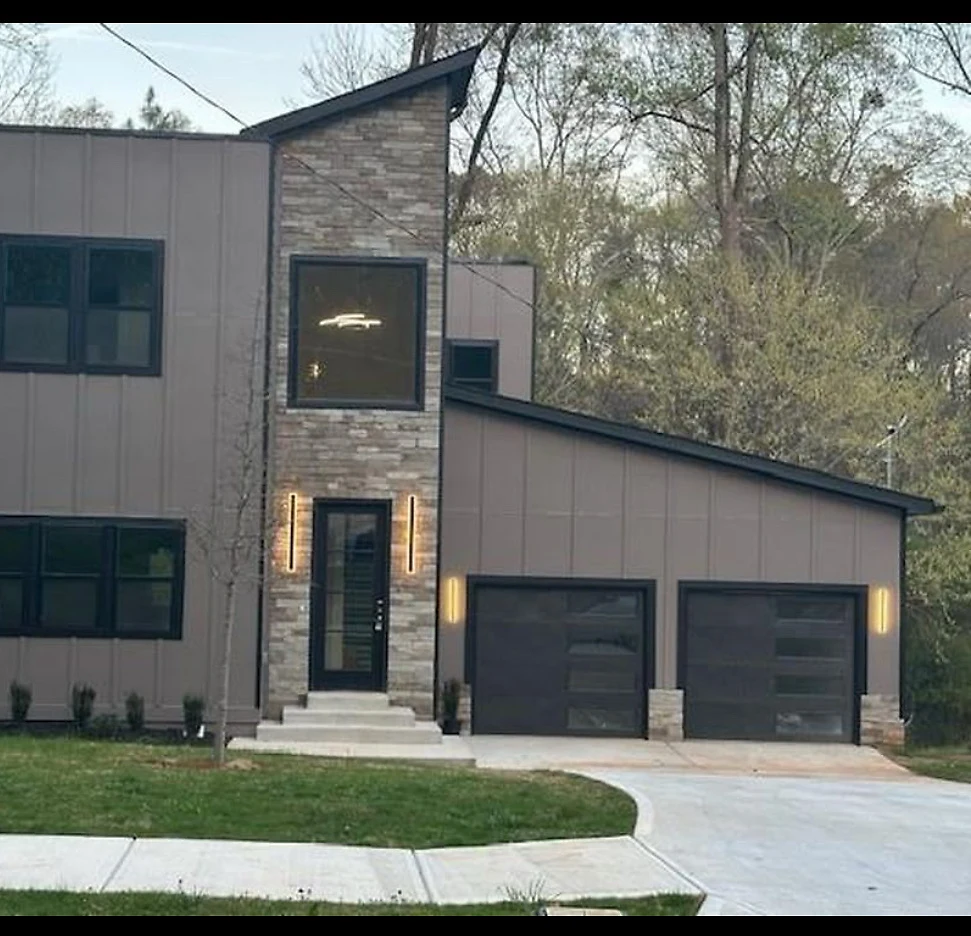 Modern custom home with stone and standing-seam detailing at dusk