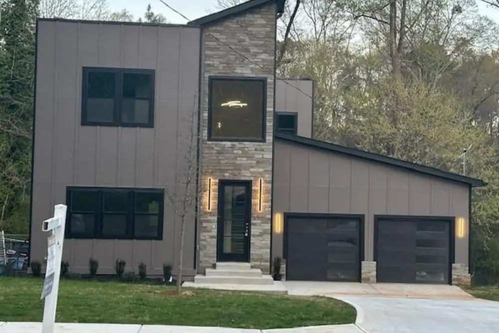 Modern custom home with stone and standing-seam detailing at dusk