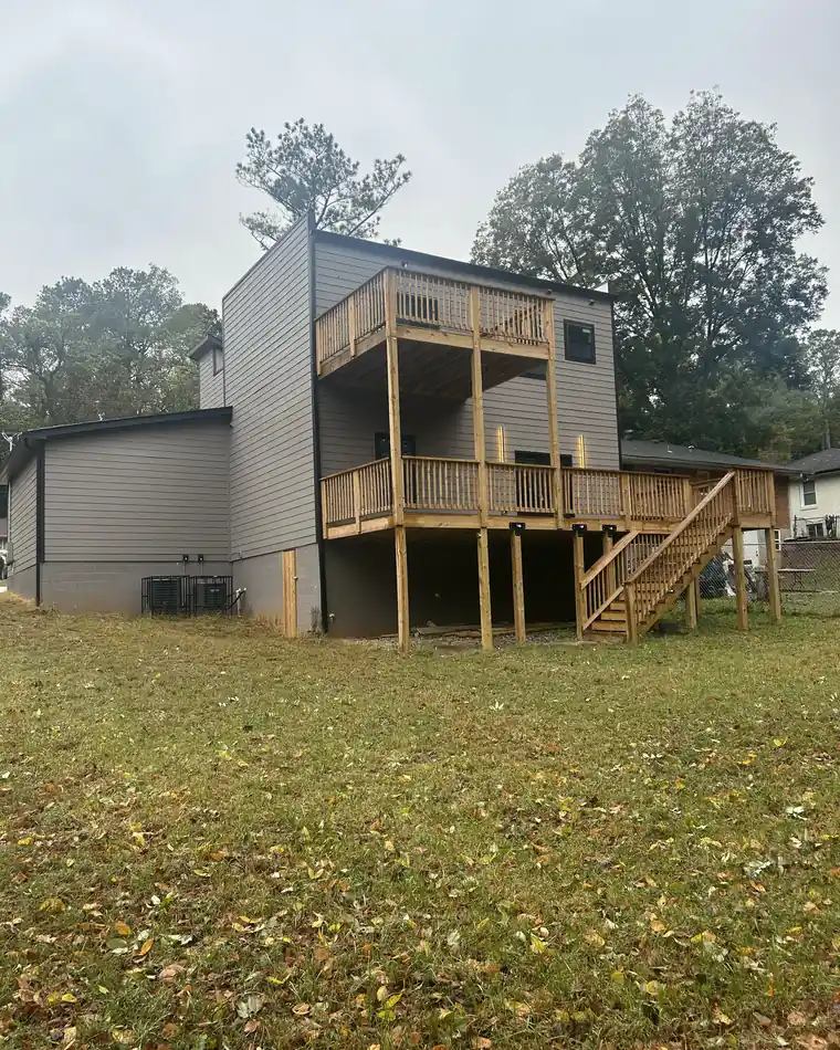 Rear elevation of a NirvanaDeshaun home with a two-story elevated deck