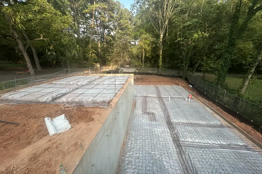Basement slab with a tied rebar grid and vapor barrier ready for the pour
