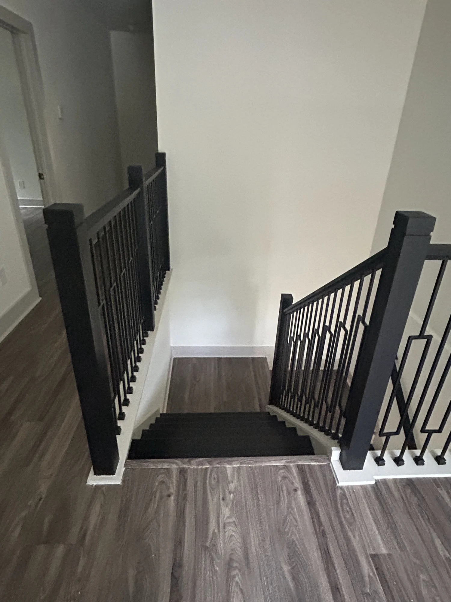 Finished staircase with a blackened steel railing and white oak treads